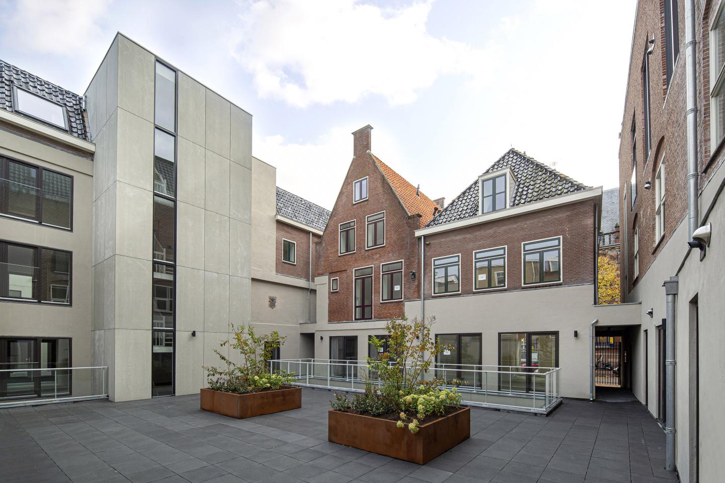Achterzijde van Het Museum met glazen balustrade en bloembakken