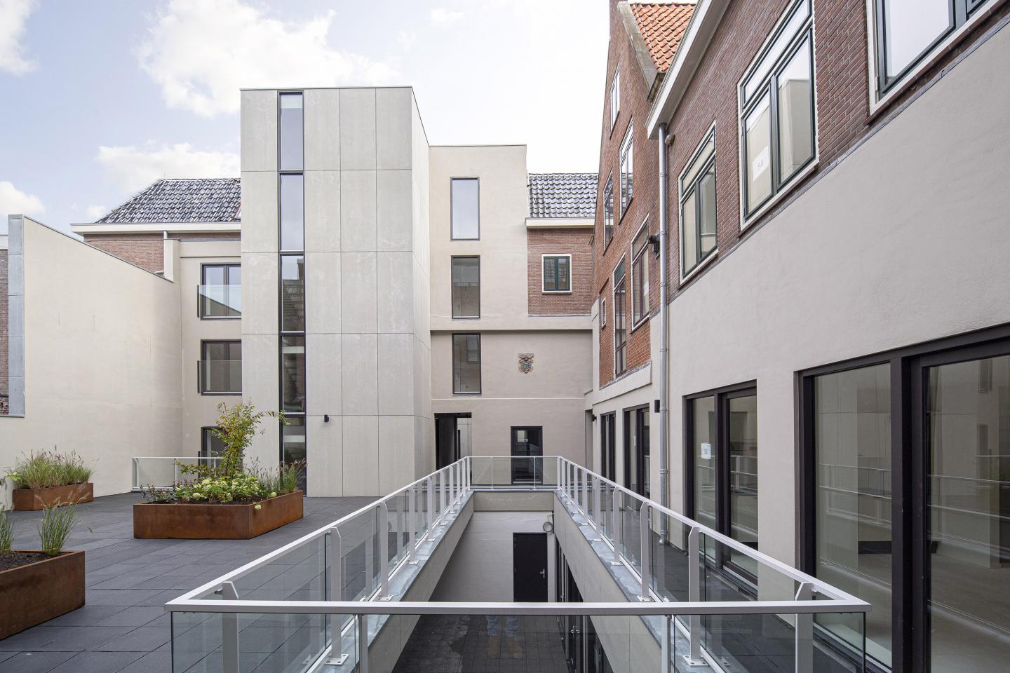 Achterzijde van Het Museum met glazen balustrade en bloembakken