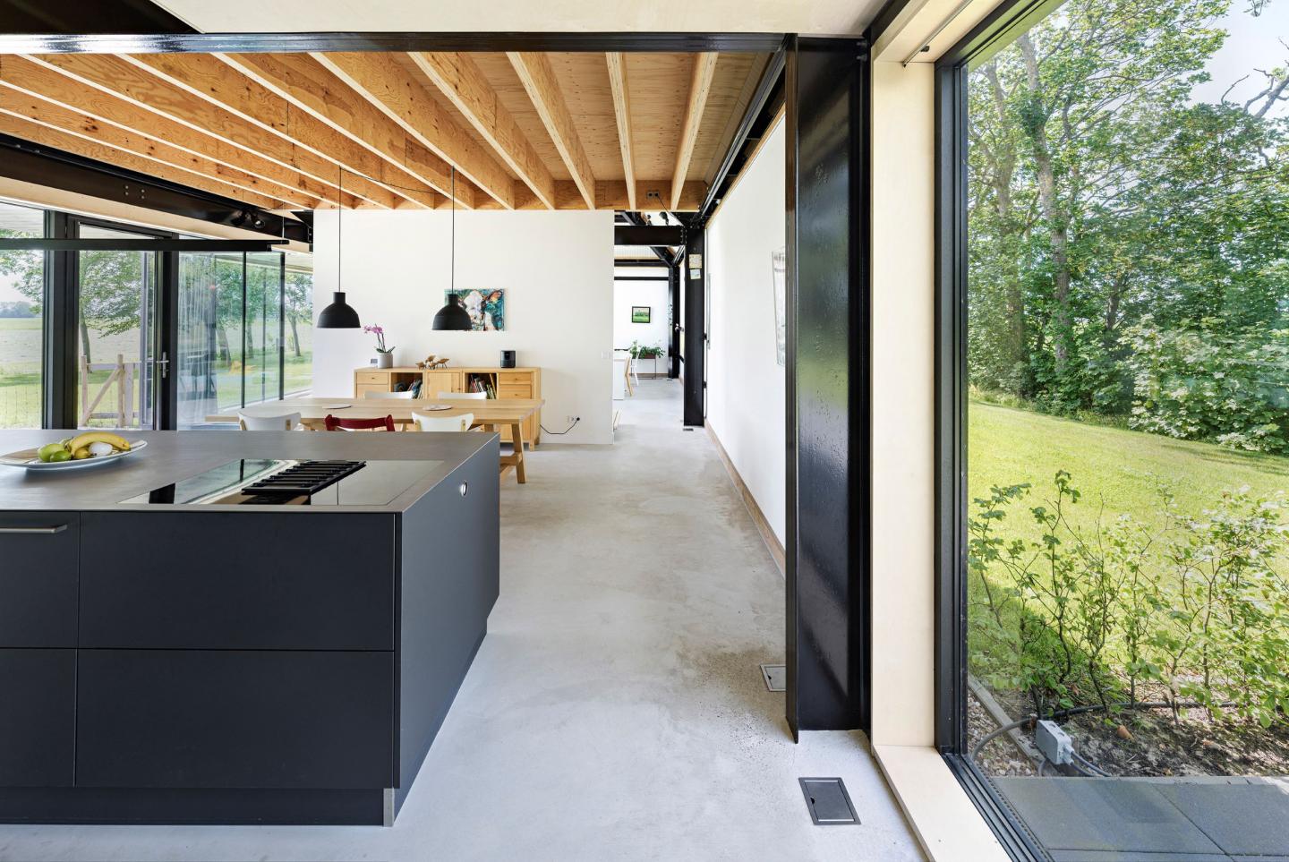 Interieur van nieuwe schuurboerderij met zwarte keuken en hout