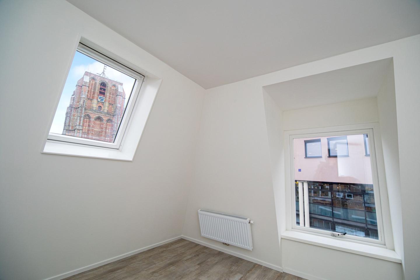 Twee ramen in appartement met uitzicht op de Oldehove