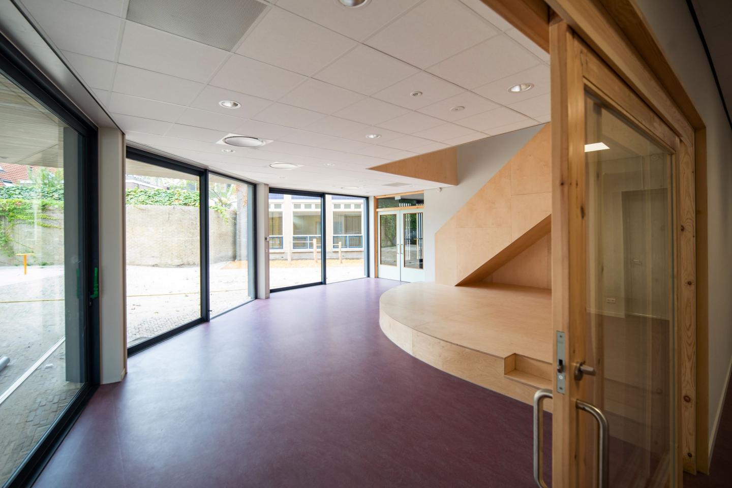 Doorkijkje in hal van school met houten trap