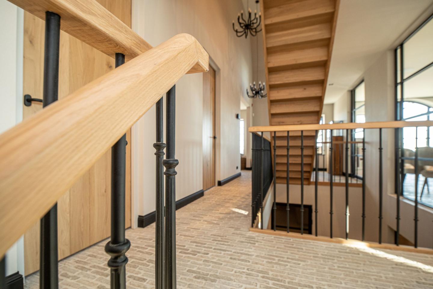 Overloop met trapleuningen en castle stone vloer