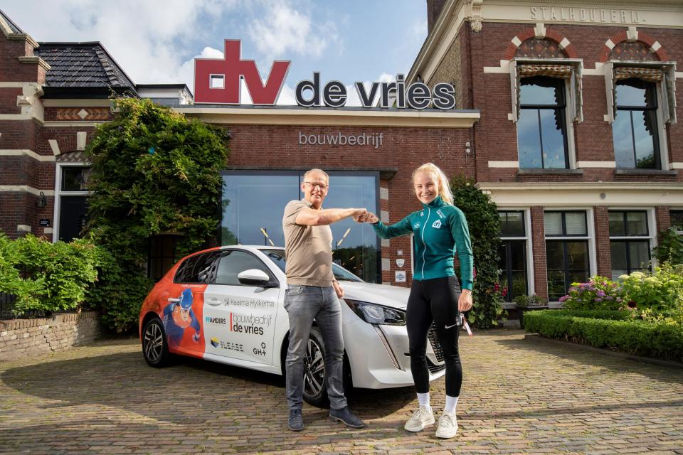 Marijke Groenewoud en Albert Adema staan voor auto met bestickering